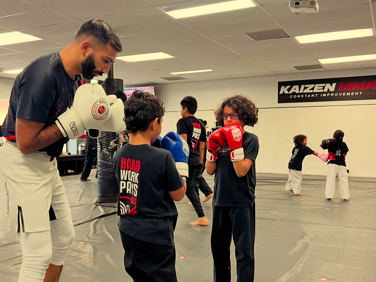 Kids practicing with gloves under coach supervision